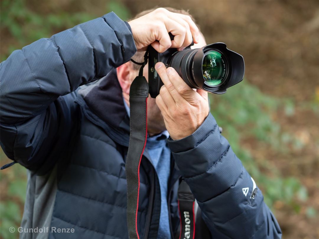 Person fotografiert mit Kamera in Natur
