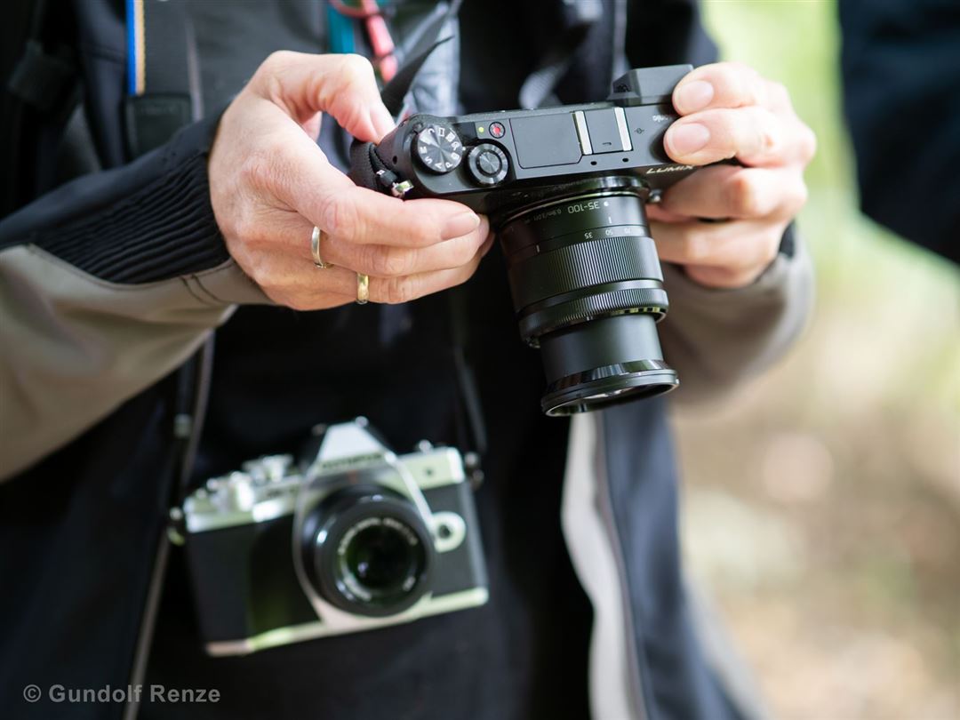 Person h&auml;lt digitale und analoge Kamera