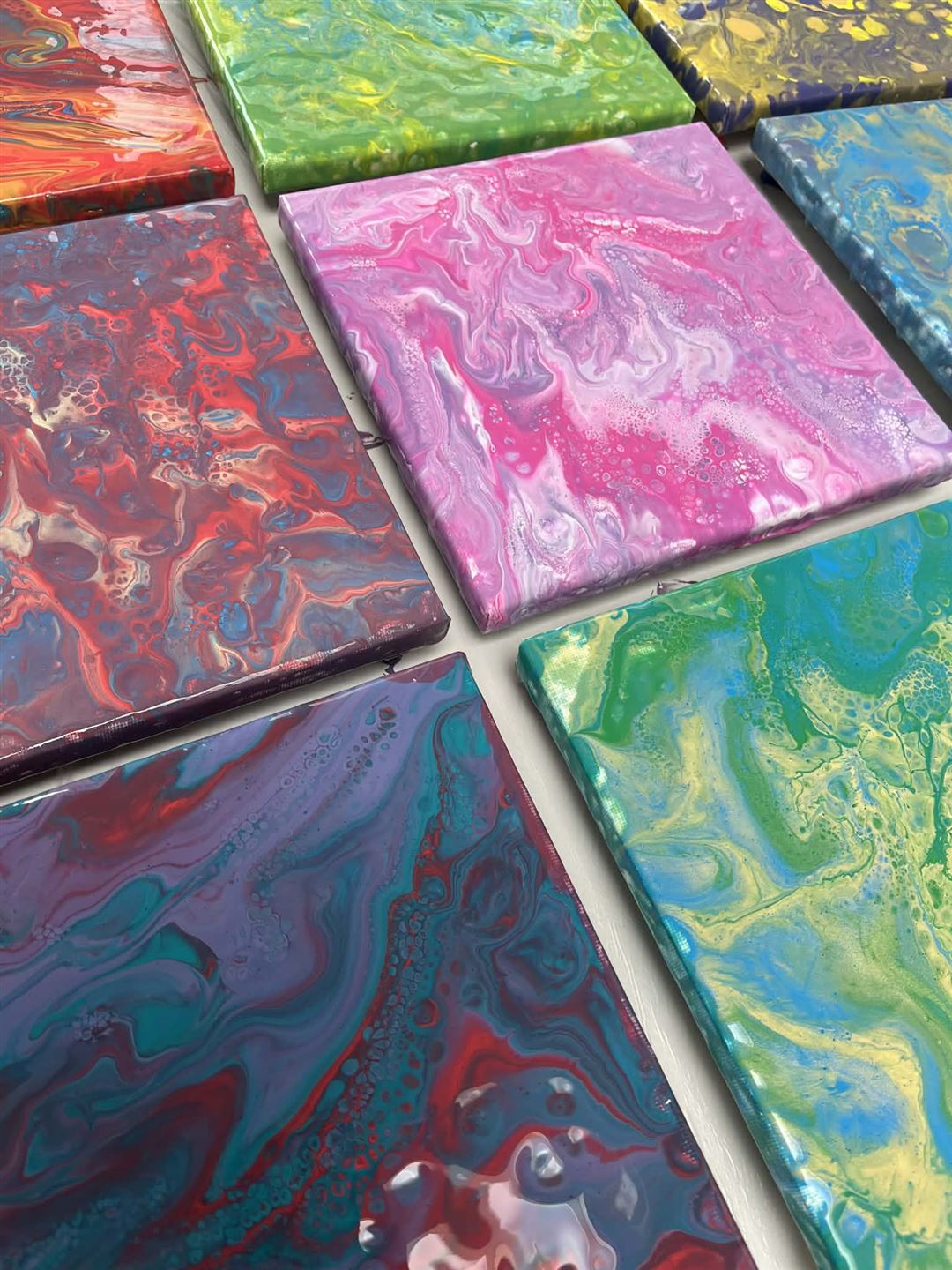 Mehrere Leinw&auml;nde mit Farbe auf Tisch liegend