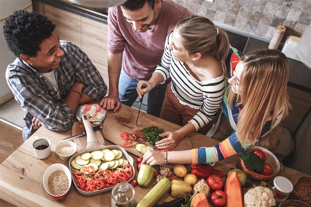 Gruppe junger Menschen bereitet gemeinsam Essen zu