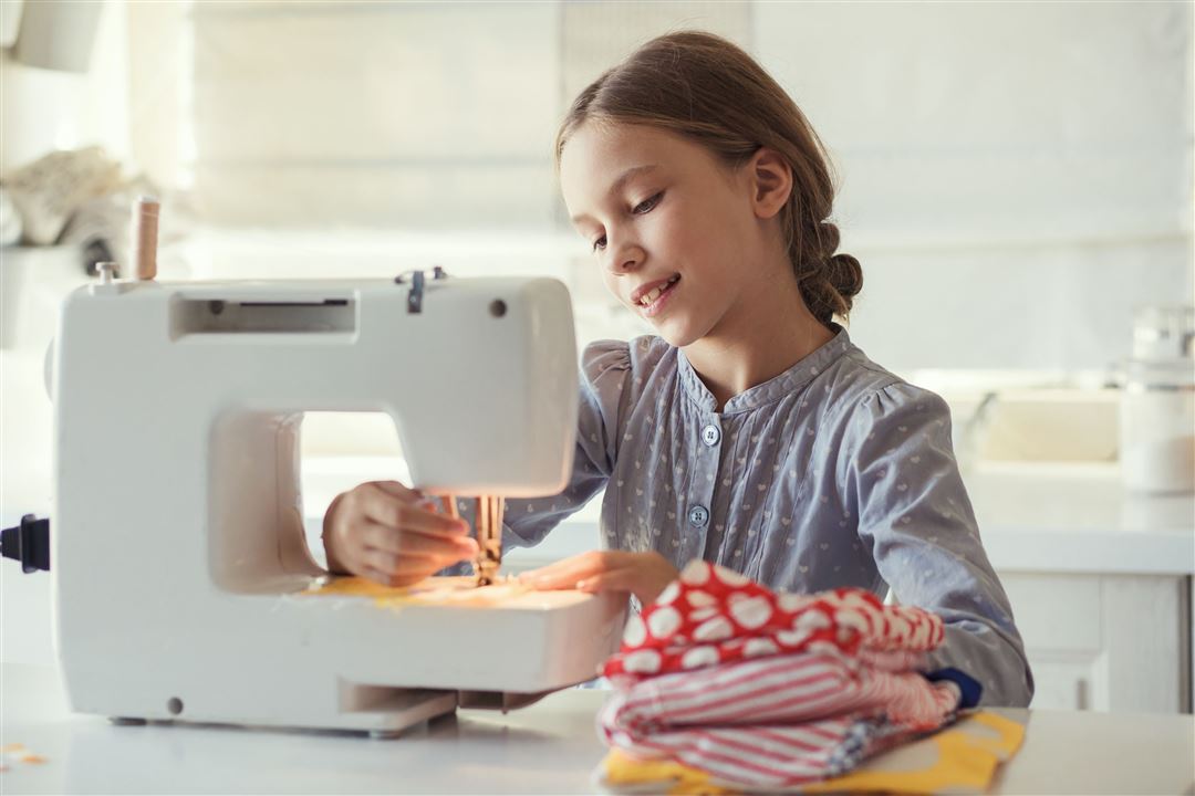 Junges M&auml;dchen n&auml;ht mit einer N&auml;hmaschine