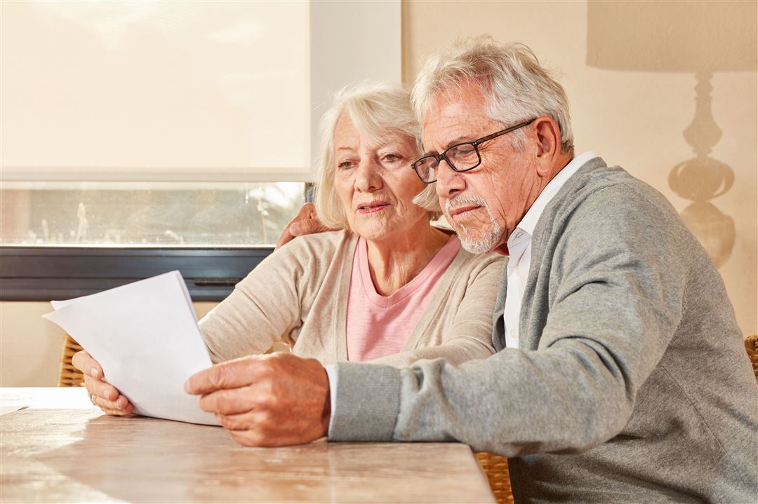 Senioren Paar liest zusammen einen Vorsorgeplan
