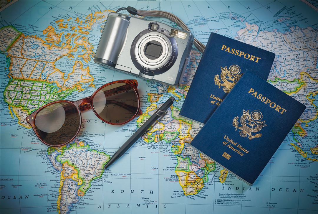 Weltkarte mit Reisepass und weiteren Reiseutensilien