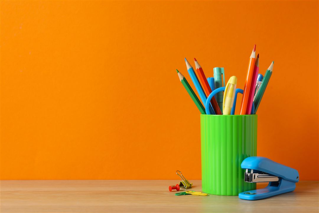 Stiftehalter mit bunten Stiften auf Holztisch 